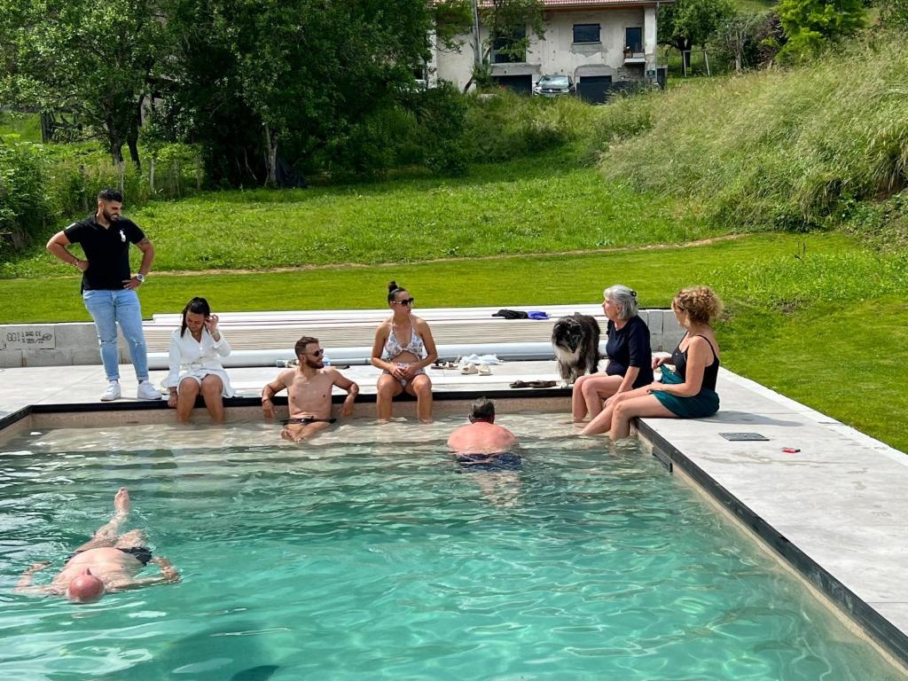un grupo de personas sentadas en una piscina en villa florian et vally, en Charvonnex