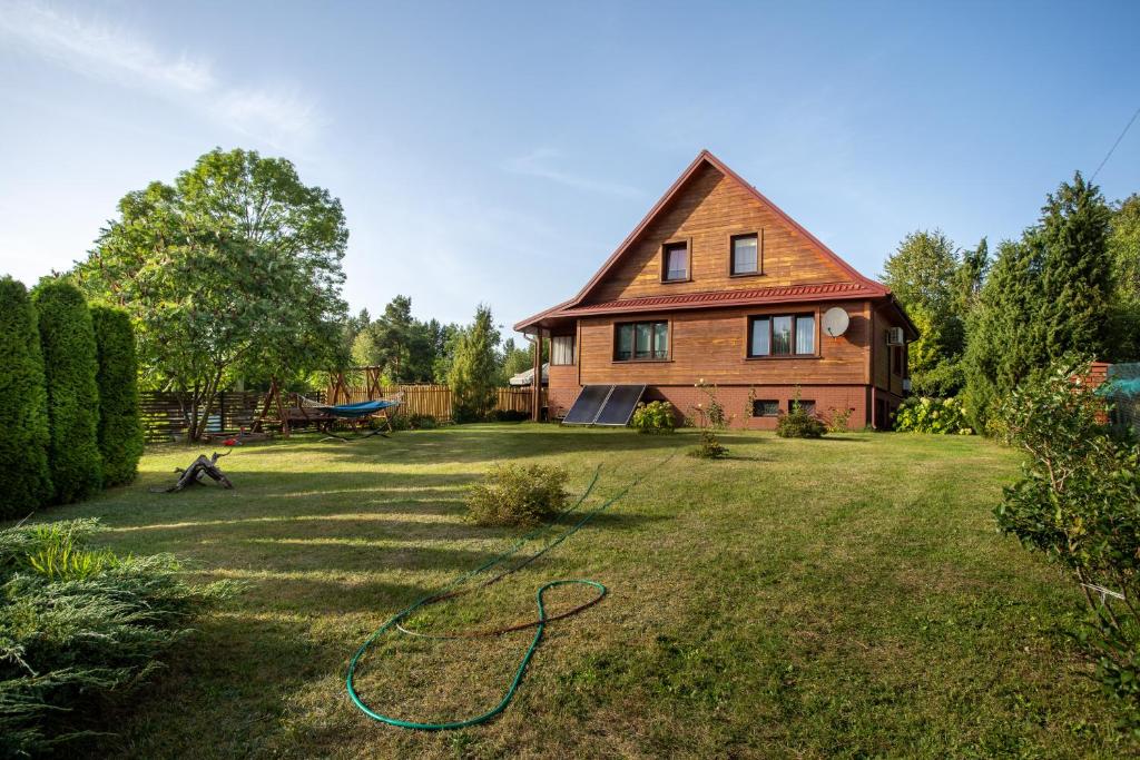 a house with a green hose in the yard at Pokoje Gościnne Szpak in Białowieża