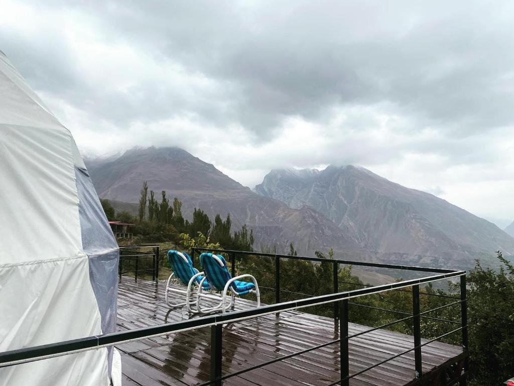 two chairs on a deck with mountains in the background at SG Glamping Resort in Hunza