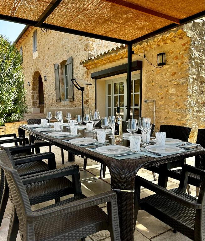 - une grande table avec des chaises et des verres sur la terrasse dans l'établissement Nouvelle Annonce Bastide Saint Louis du Thoronet, à Carcès