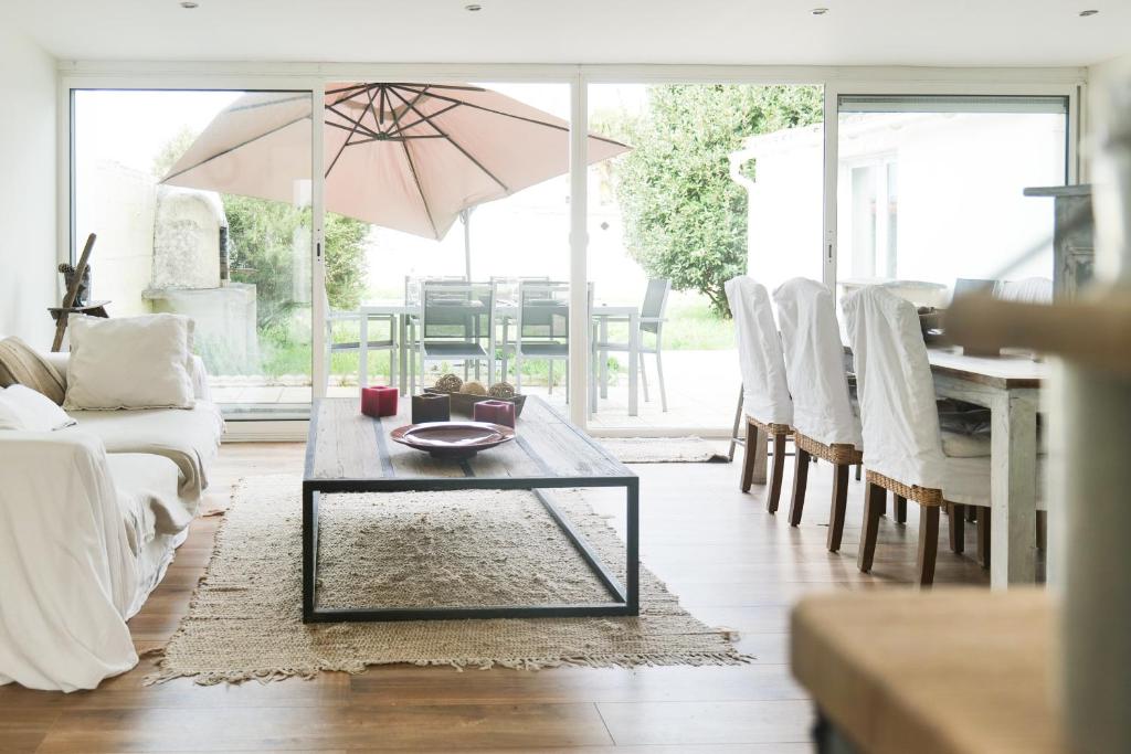- un salon avec une table et un parasol dans l'établissement Jolie maison rénovée proche centre ville Les Sables 9 personnes, à Les Sables-dʼOlonne
