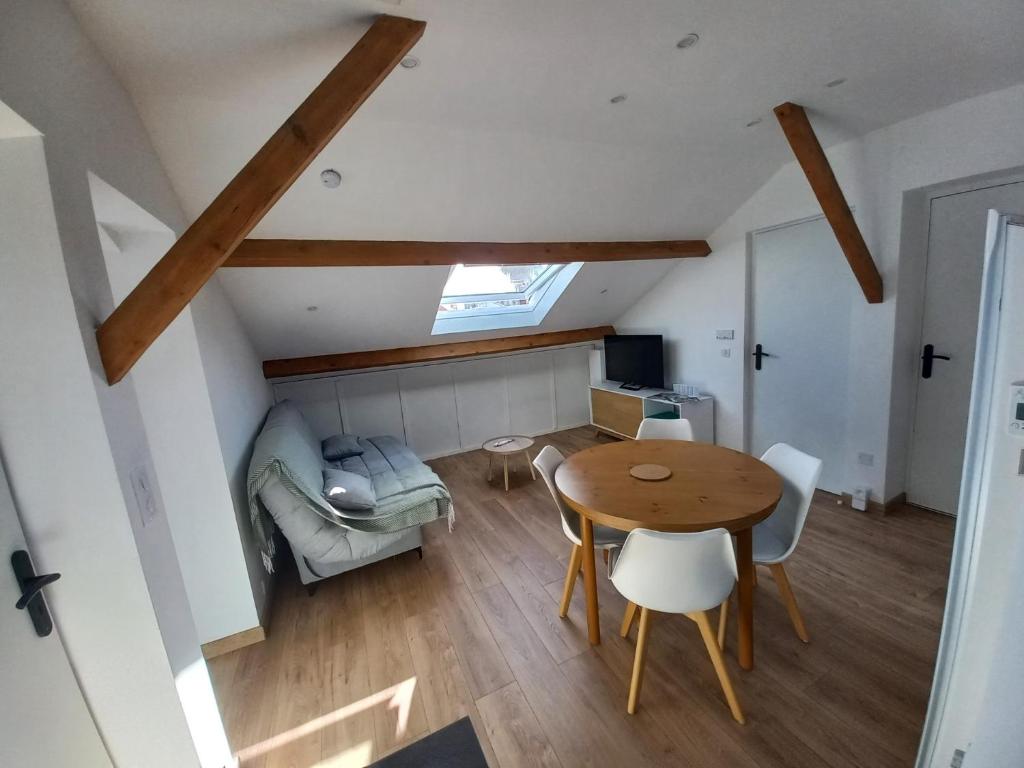 Cette petite chambre comprend une table et un lit. dans l'établissement Chez Marina et Morgan Appartement 2 chambres, à Pornic