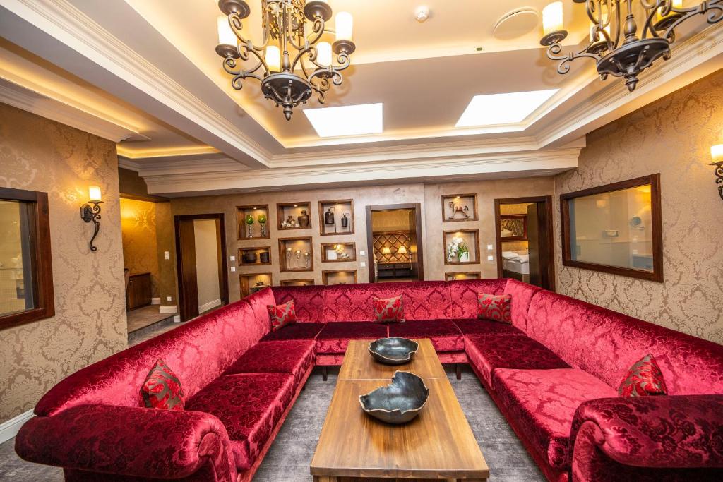 a living room with a red couch and a table at Hotel Dvorana in Karlovy Vary