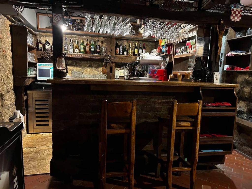 un bar avec deux chaises assises à un comptoir dans l'établissement Restoran i prenoćište Begović, à Požega