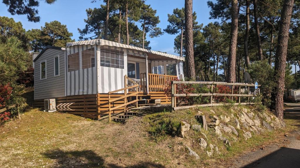 a tiny house on a hill with a fence at Mobilhome Eleganzia 713 Bonne Anse Plage in Les Mathes
