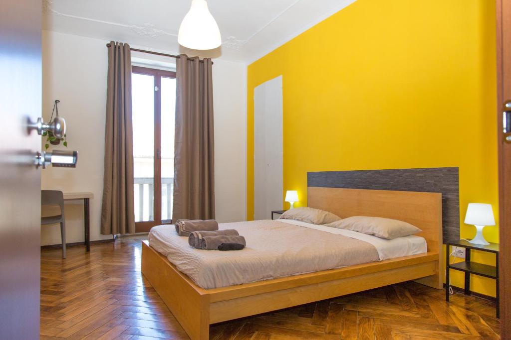 um quarto com uma cama grande e paredes amarelas em Guest House Turin Metro Young em Turim