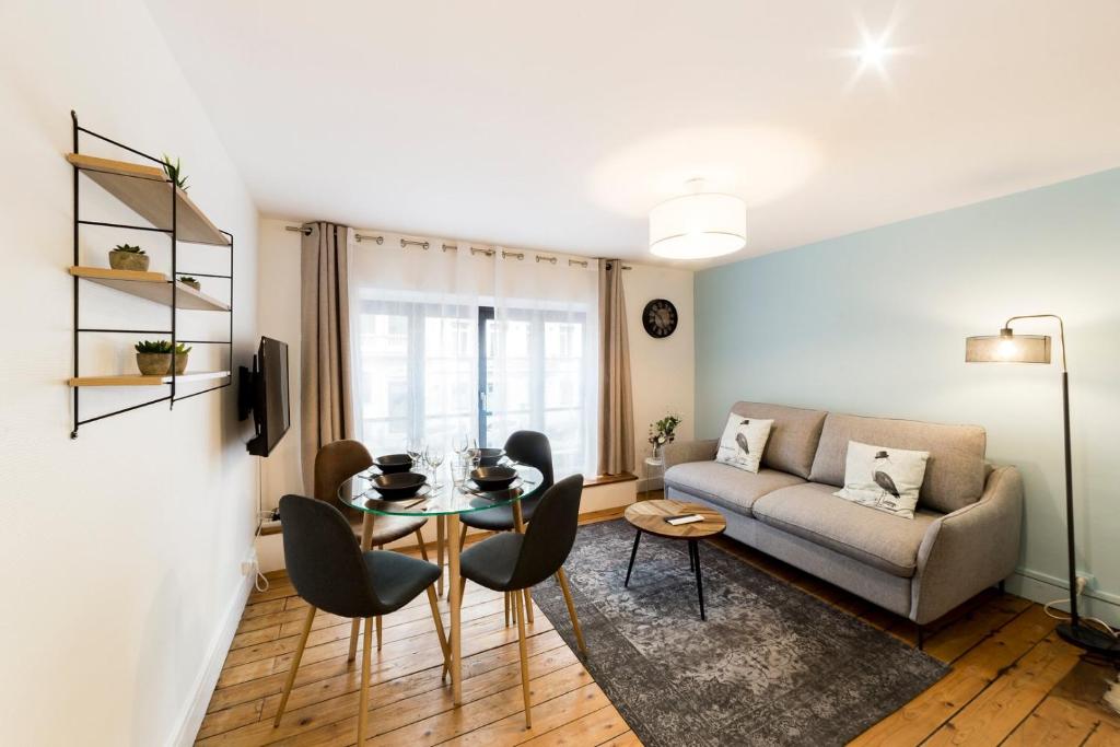 un salon avec un canapé et une table dans l'établissement Appartement au cœur du 6ème arrondissement AIL, à Lyon