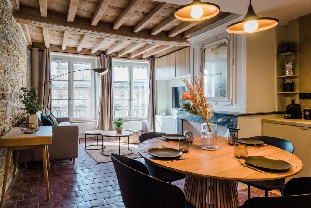 Il dispose d'une cuisine et d'un salon avec une table et des chaises en bois. dans l'établissement La Balnéo des Terreaux AIL, à Lyon