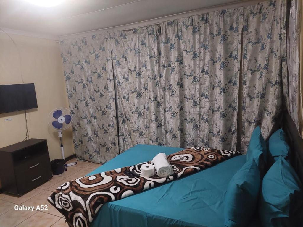 a bedroom with a bed with a teddy bear on it at COMFORT ZONE GUEST HOUSE in Zeerust