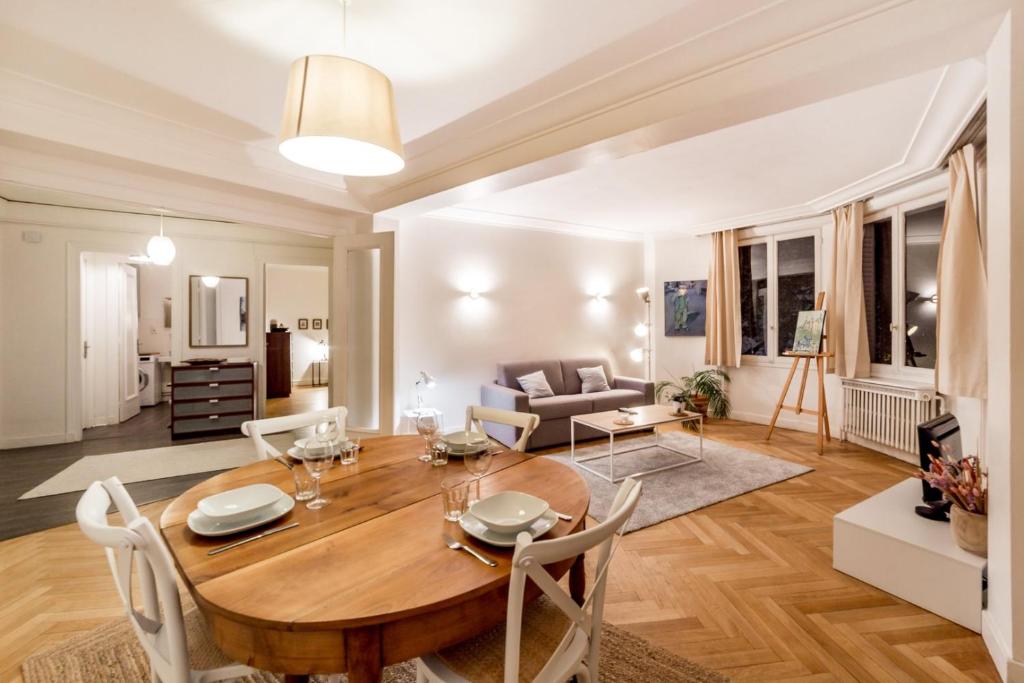 a living room with a wooden table and a couch at Spacious and bright 70m² square AIL in Lyon