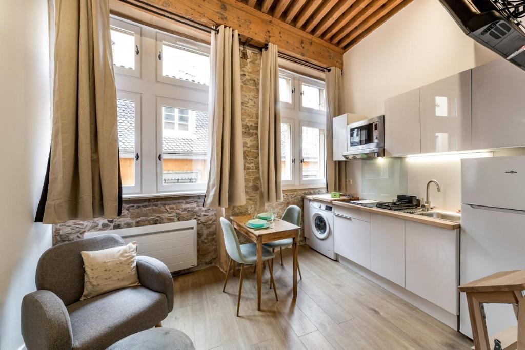 une cuisine avec une chaise et une table dans une pièce dans l'établissement studio de charme au cœur de Lyon AIL, à Lyon