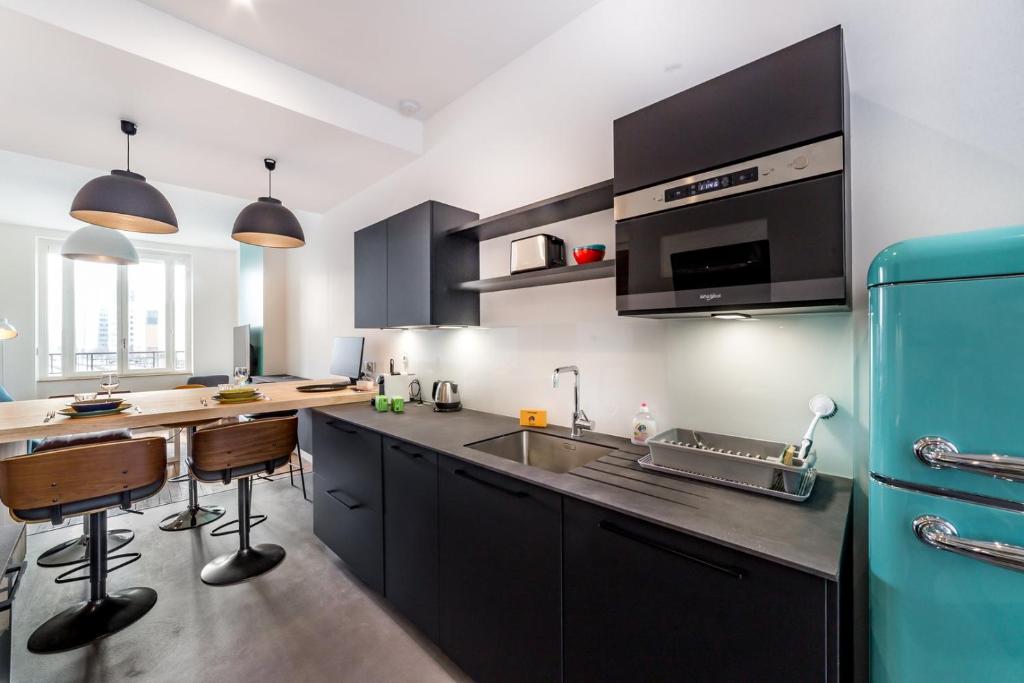 a kitchen with black cabinets and a blue refrigerator at Brand new apartment 2022 Lyon Part-Dieu AIL in Lyon