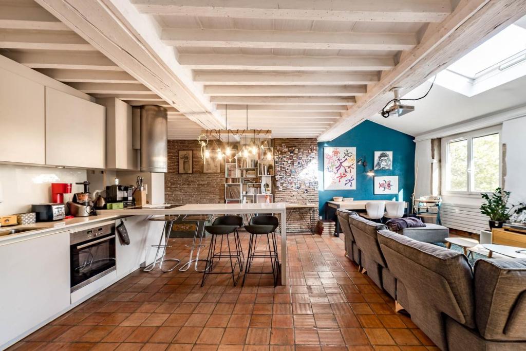 une cuisine ouverte et un salon aux murs bleus dans l'établissement Bel appartement du Vieux Lyon - parking inclus AIL, à Lyon