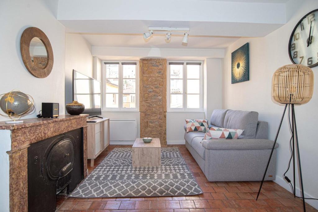 ein Wohnzimmer mit einem Sofa und einem Kamin in der Unterkunft Modern and cozy in the heart of Saint-Jean AIL in Lyon