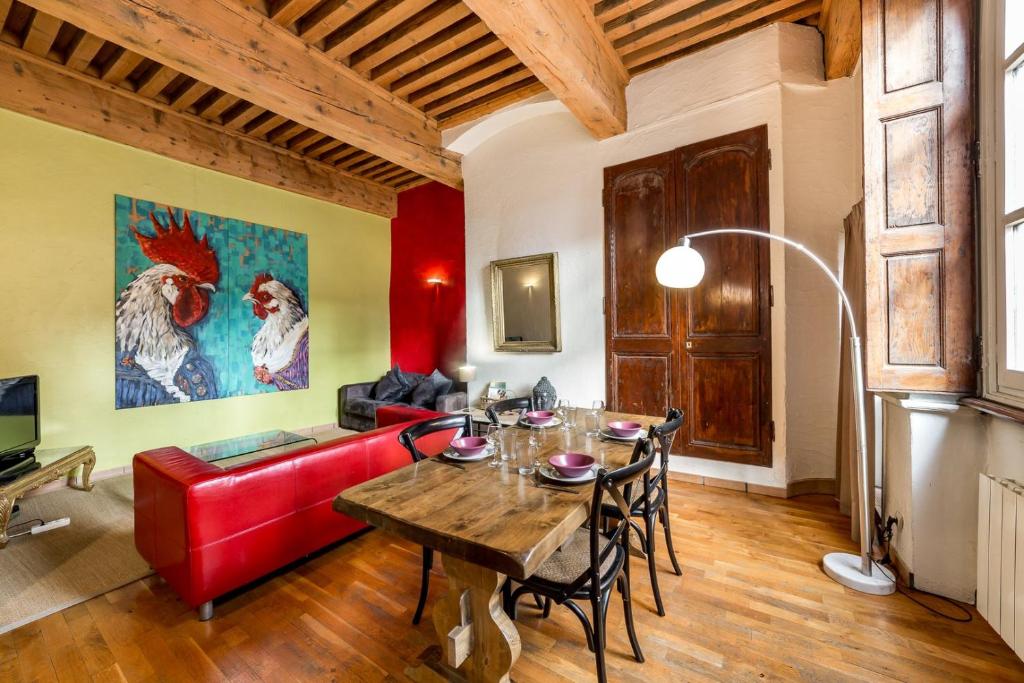 un salon avec une table et un canapé rouge dans l'établissement La Loge des Avocats du vieux Lyon AIL, à Lyon