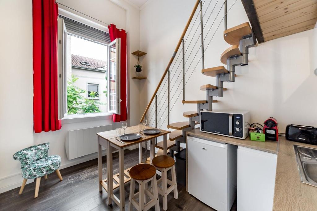 a small kitchen with a table and a staircase at The charming studio in Croix-Rousse AIL in Lyon