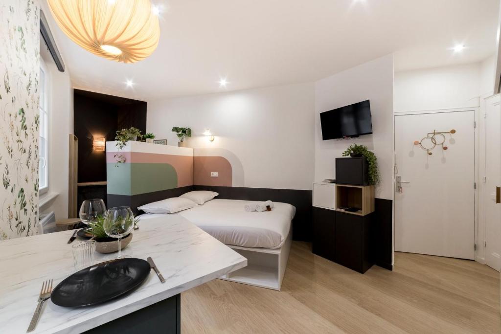 um quarto de hotel com uma cama e uma mesa com um lavatório em Pleasant decorator's studio - Near Metro AIL em Lyon
