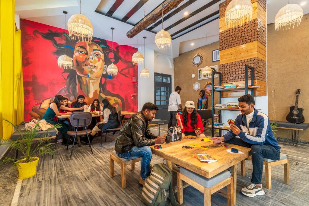 um grupo de pessoas sentadas numa mesa num restaurante em The Hosteller Kasol, Parvati Valley em Kasol