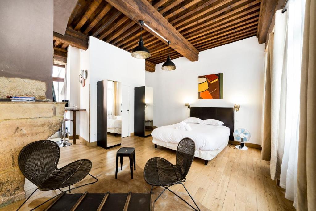 - une chambre avec un lit et des chaises dans l'établissement Authentic studio in Vieux Lyon AIL, à Lyon