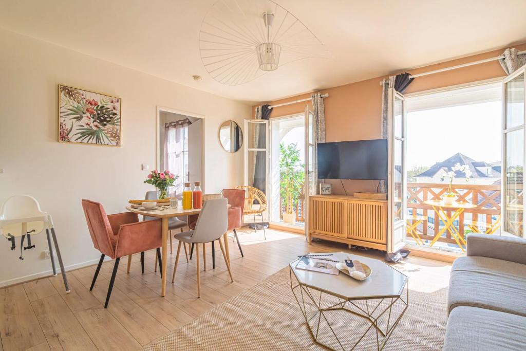 uma sala de estar com um sofá e uma mesa em DISNEYLAND - WIFI - PARKING - CENTRE VILLE em Bailly-Romainvilliers