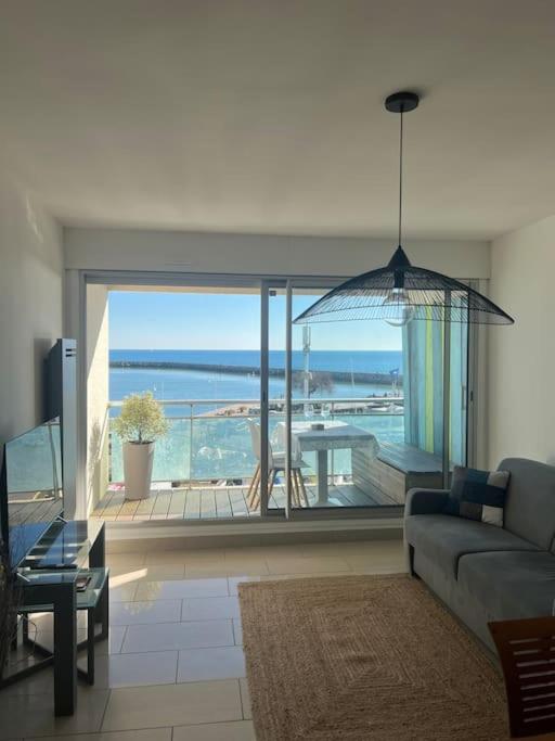 a living room with a couch and a view of the ocean at Superbe Appartement Vue Mer T3 70m2 in Mauguio
