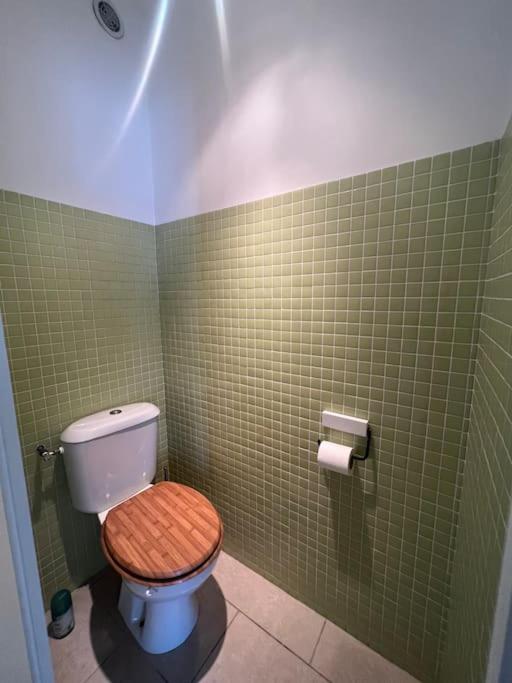 a bathroom with a toilet with a wooden toilet seat at Superbe Appartement Vue Mer T3 70m2 in Mauguio