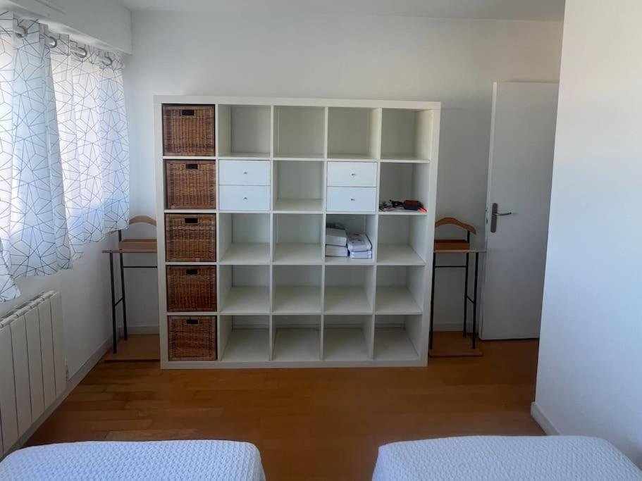 a white book shelf in a room with a window at Superbe Appartement Vue Mer T3 70m2 in Mauguio