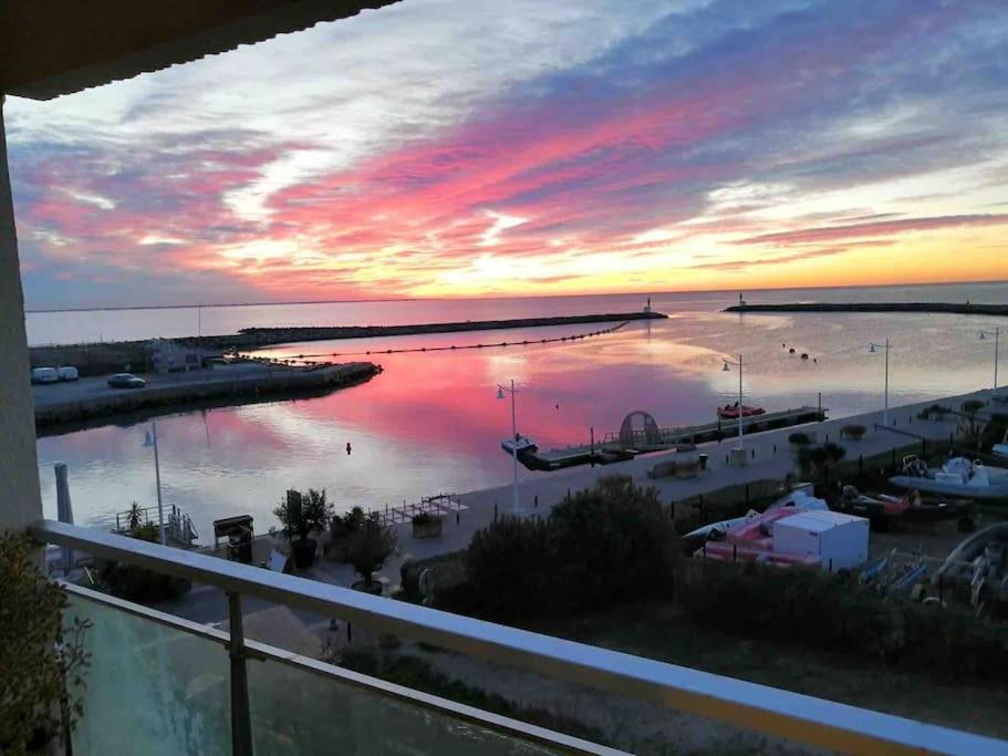 a view of a marina at sunset from a balcony at Superbe Appartement Vue Mer T3 70m2 in Mauguio