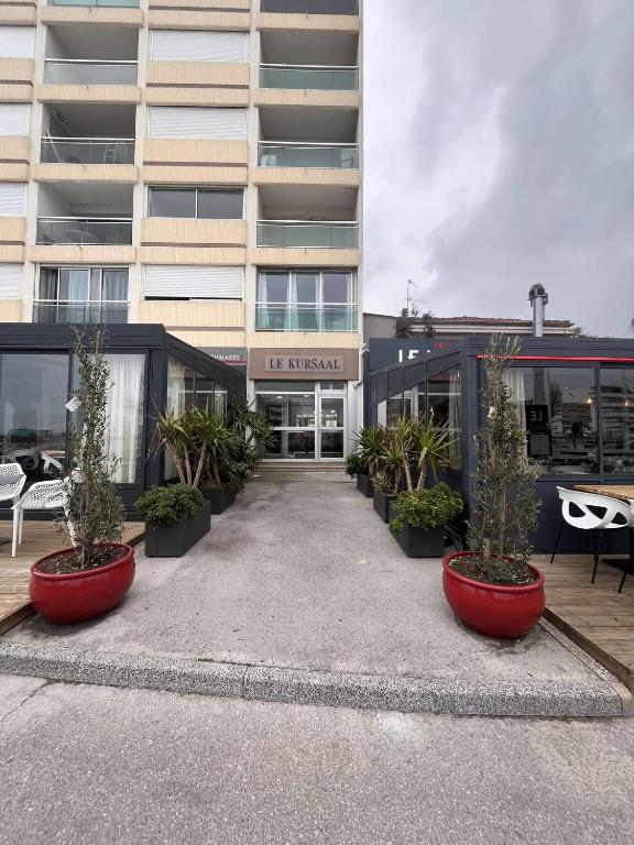 a building with potted plants in front of it at Superbe Appartement Vue Mer T3 70m2 in Mauguio