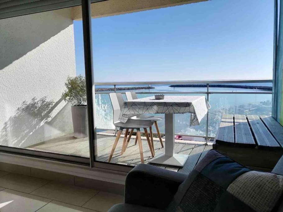 a view of a balcony with a table and chairs at Superbe Appartement Vue Mer T3 70m2 in Mauguio