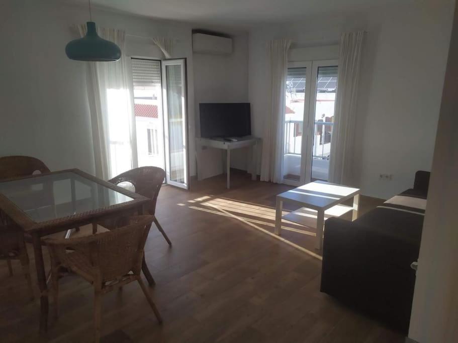 a living room with a dining table and a television at Apartamento La Mar in Carboneras