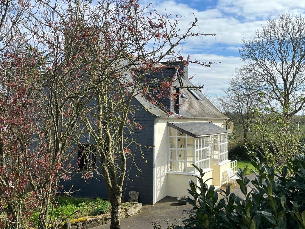 a small house with a black and white at Bri29 - Poullaouen - Murmur-y-coed in Poullaouen