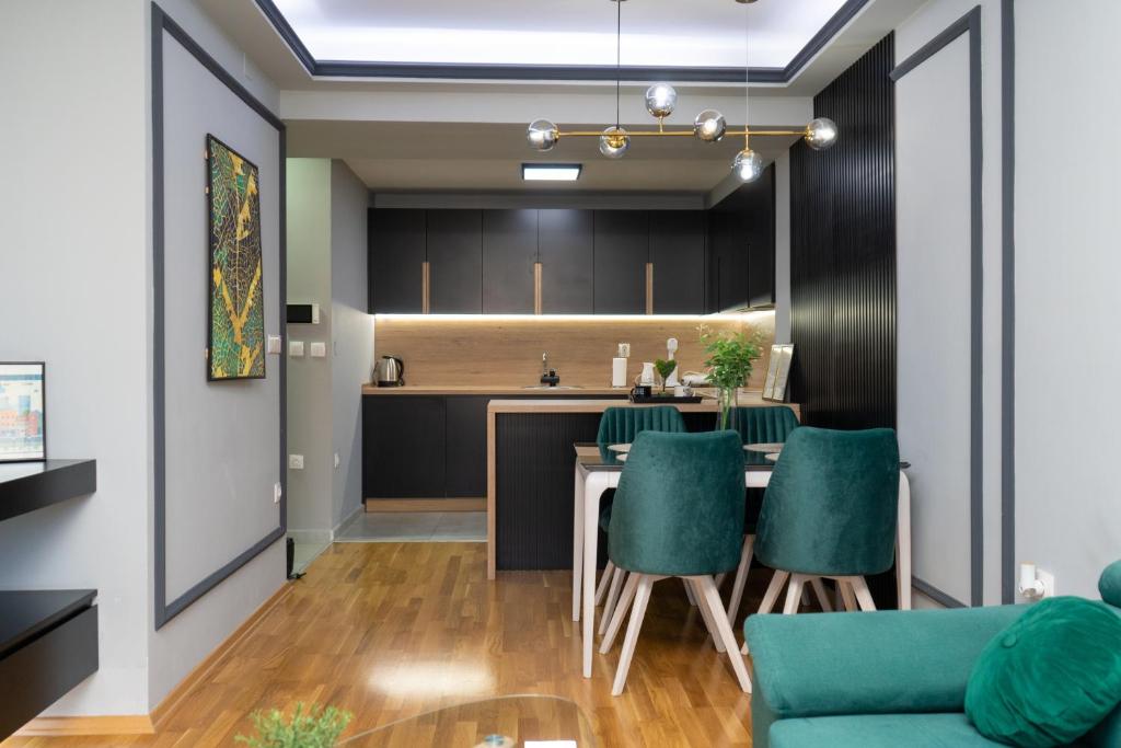 une cuisine et une salle à manger avec une table et des chaises vertes dans l'établissement Unity Luxury Apartment - Skopje, à Skopje