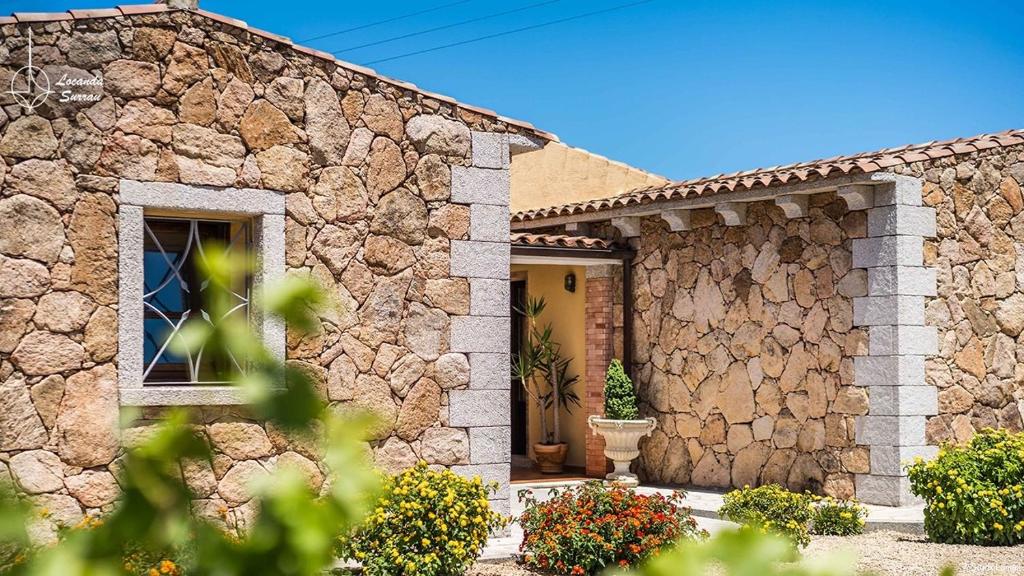 Casa de piedra con puerta delantera y ventana en Locanda in Vigna, en Arzachena