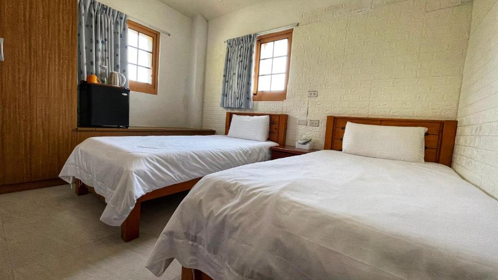 北竿鄉的住宿－芹壁梅好石屋 Mayhao Stone House，一间卧室配有两张床和电视。