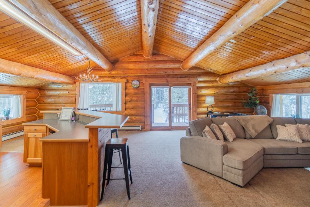 a living room with a couch and a desk at Tucked Away Timbers in Fairbanks