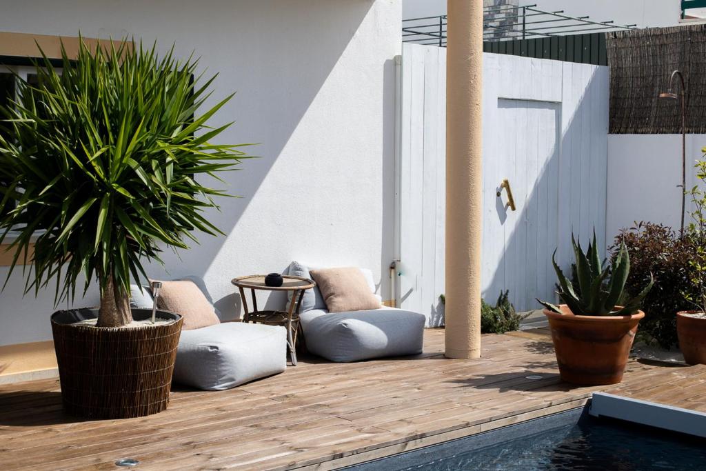 a patio with two chairs and a table and plants at Casa Idalia Boutique Hotel in Comporta