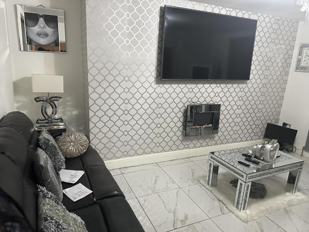 a living room with a couch and a tv on a wall at Beautiful 1-Bed House in Bradford in Bradford