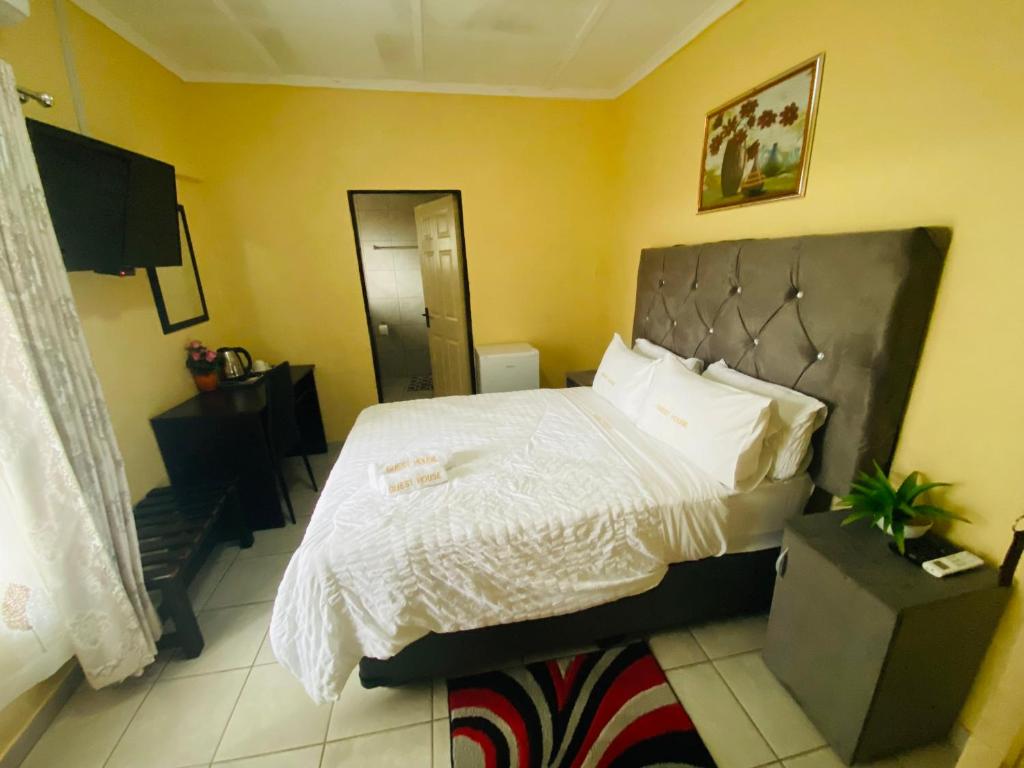 une chambre avec un grand lit avec des draps blancs dans l'établissement Lalamnandzi 4, à White River
