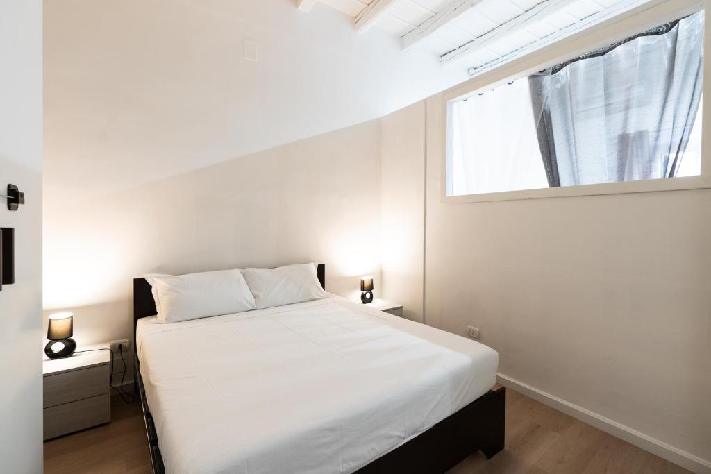 - une chambre avec un lit blanc et une fenêtre dans l'établissement Giardini del Castello Apartment, à Barletta