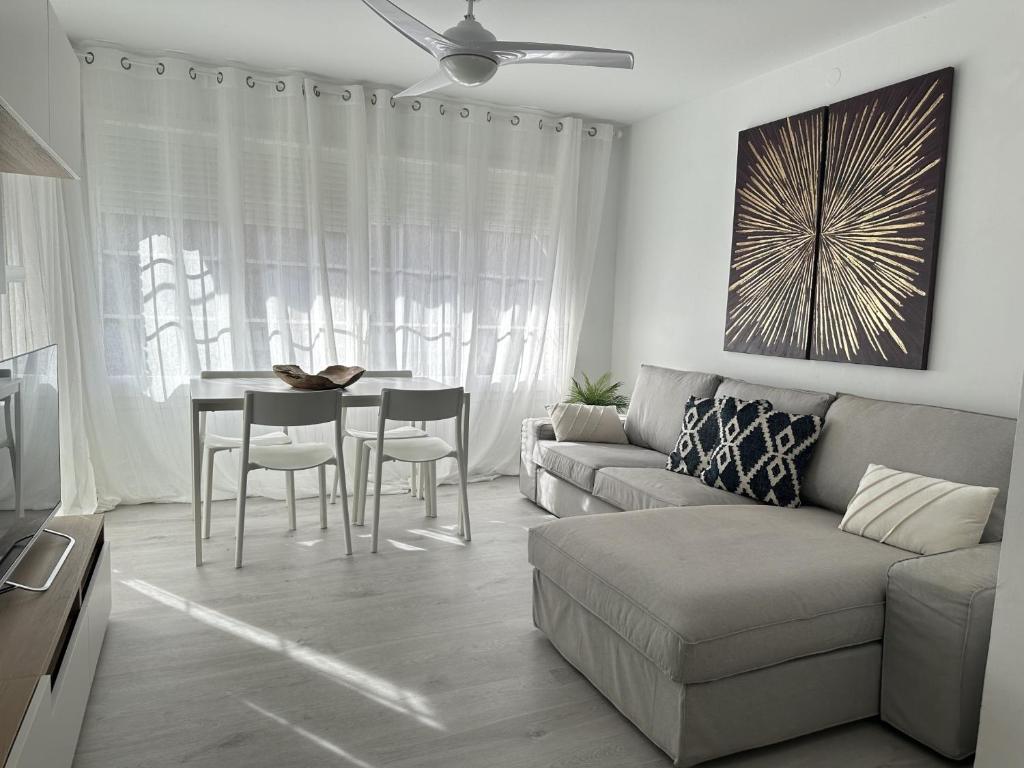 カステルデフェルスにあるApartamento frente al mar Apoloのソファとテーブルのあるリビングルーム