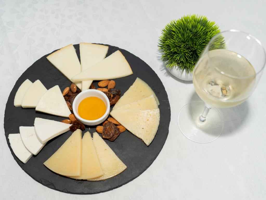a plate of cheese and nuts and a glass of wine at Balneario Pozo de la Salud in Sabinosa