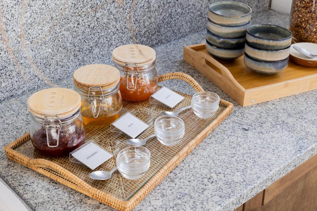 a tray with jars of honey and spoons on a counter at Casa Idalia Boutique Hotel in Comporta
