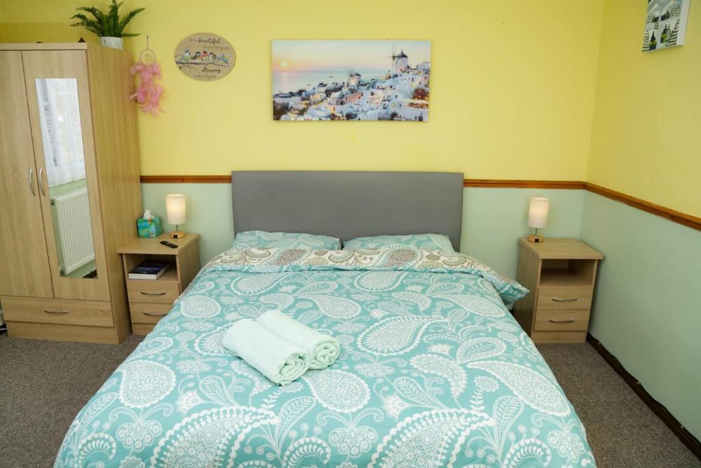 ein Schlafzimmer mit einem Bett mit zwei Handtüchern darauf in der Unterkunft Lux House in Peterborough