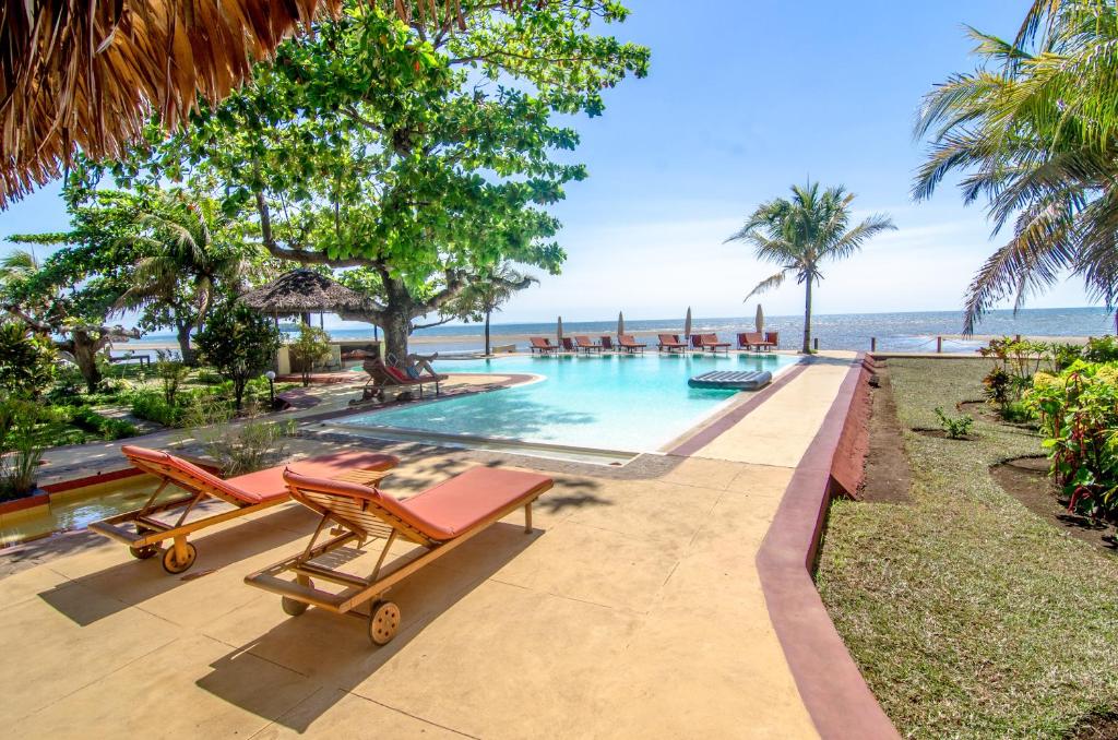 a swimming pool with a view of the ocean at Hotel Arc En Ciel in Dzamandzar