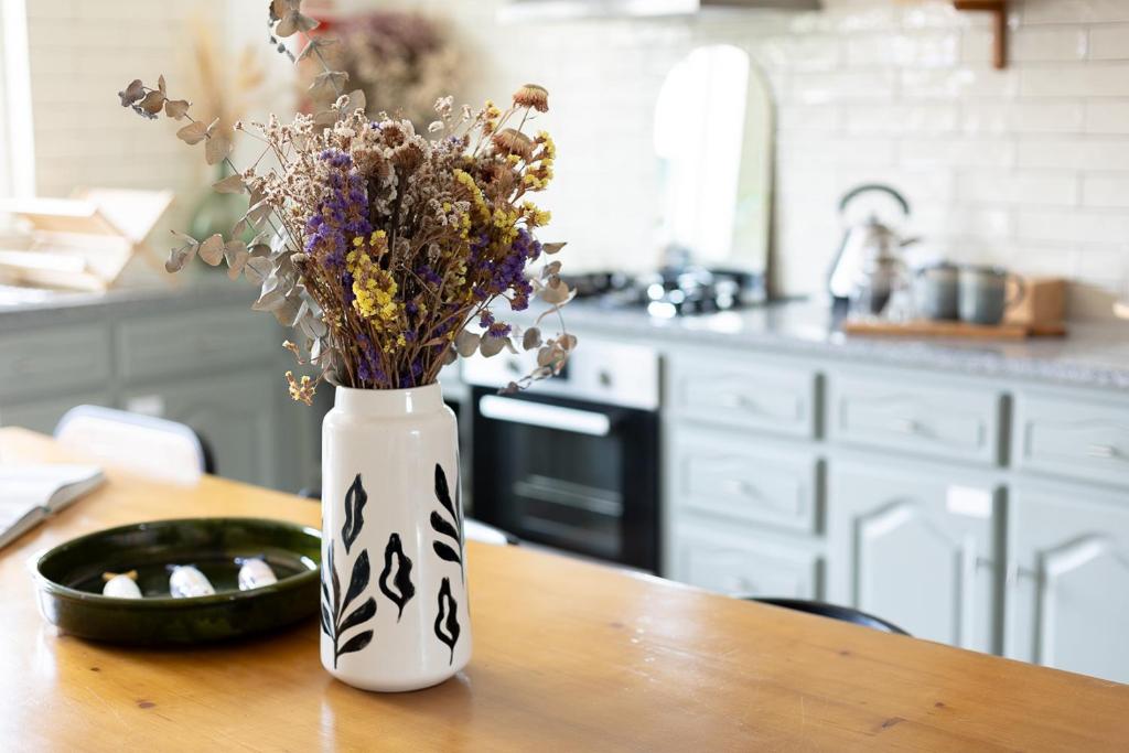 a vase with flowers sitting on a table in a kitchen at Casa Idalia Boutique Hotel in Comporta