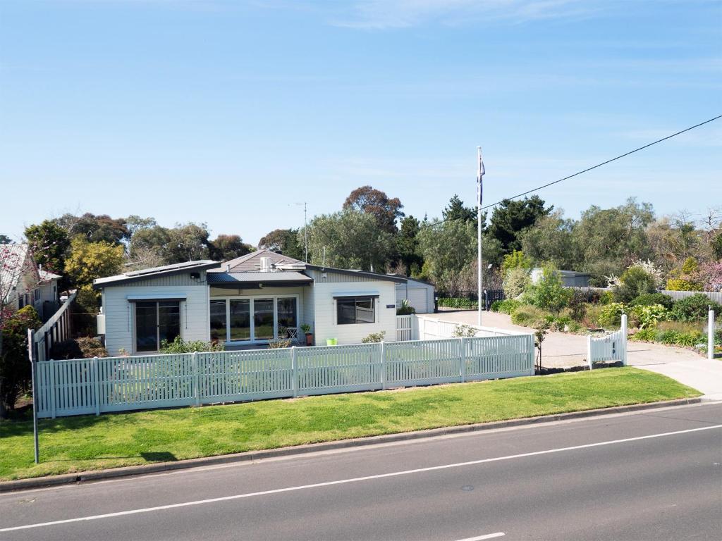 a house with a blue fence on the side of the road at Coppards Rest in Geelong