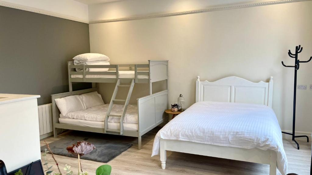 都柏林的住宿－Spires studio，一间卧室配有双层床和白色的床。