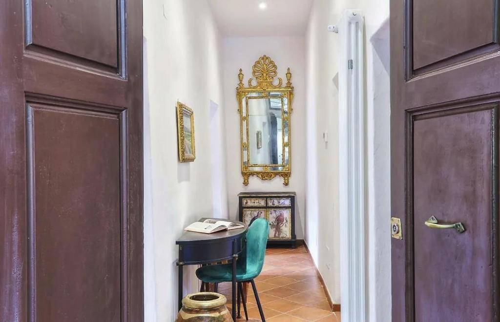 um corredor com uma mesa, uma cadeira e um espelho em Corallo Suite em Pisa