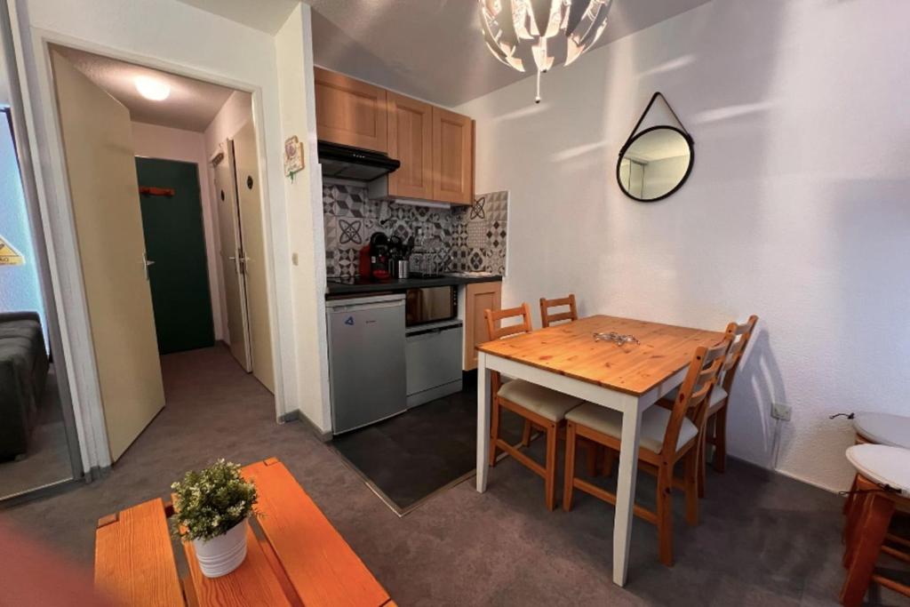 cocina y comedor con mesa y sillas en Modern apartment at the foot of the slopes, en La Plagne Tarentaise